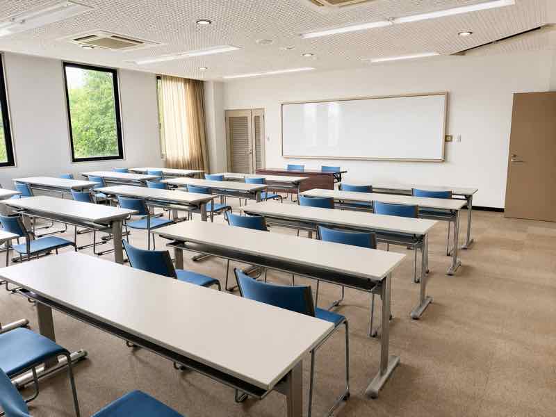 ホワイトボードと青い椅子を備えた、明るく清潔な教室