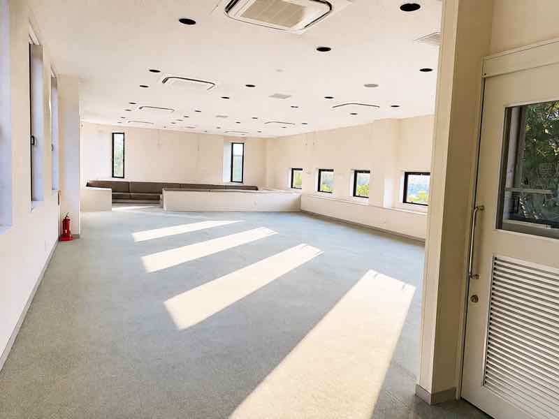 窓から自然光が差し込む、ソファを備えた広い共用スペース
