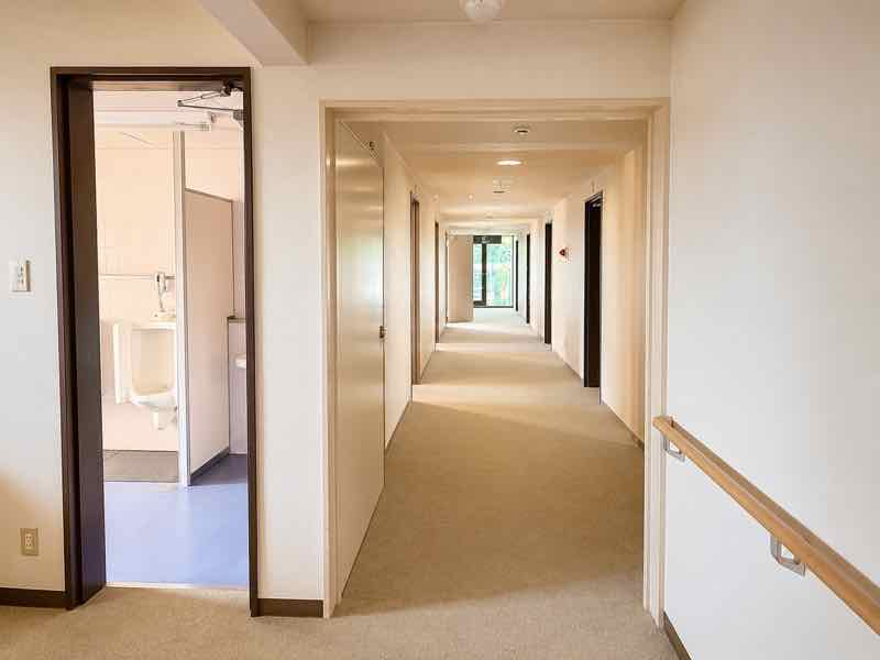 手すりと共用設備を備えた、明るく清潔な館内通路